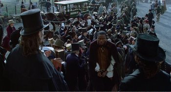 Movie still from “Amistad” (1997), directed by Steven Spielberg – A crowd of people standing around a street; Wide shot, High angle