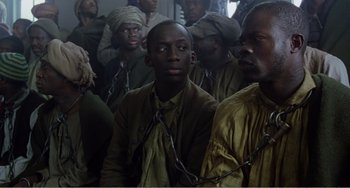 Movie still from “Amistad” (1997), directed by Steven Spielberg – A group of men sitting next to each other in a room; Medium shot, High angle