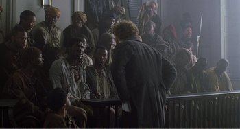 Movie still from “Amistad” (1997), directed by Steven Spielberg – A group of people sitting in front of a crowd; Wide shot, High angle
