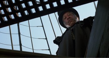 Movie still from “Amistad” (1997), directed by Steven Spielberg – An old man in a hat looking out of a window; Medium shot, Low angle