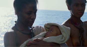 Movie still from “Amistad” (1997), directed by Steven Spielberg – A woman holding a baby in her arms on the beach; Close Up shot, Over the shoulder angle