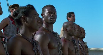 Movie still from “Amistad” (1997), directed by Steven Spielberg – A group of men standing next to each other with chains around their necks; Close Up shot, High angle