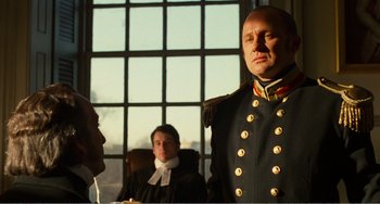 Movie still from “Amistad” (1997), directed by Steven Spielberg – A man in a military uniform is standing in front of two other men; Medium shot, Low angle