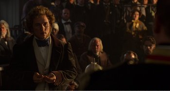 Movie still from “Amistad” (1997), directed by Steven Spielberg – A crowd of people sitting in front of a projector screen; Medium shot, Over the shoulder angle