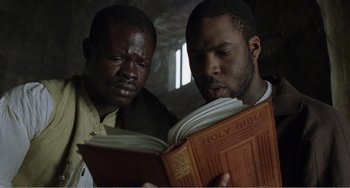 Movie still from “Amistad” (1997), directed by Steven Spielberg – A couple of men standing next to each other; Close Up shot, Low angle