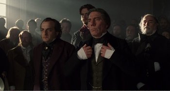 Movie still from “Amistad” (1997), directed by Steven Spielberg – A group of men standing next to each other in a dark room; Medium shot, Low angle