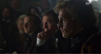 Movie still from “Amistad” (1997), directed by Steven Spielberg – A group of men sitting next to each other in a dark room; Close Up shot, Over the shoulder angle