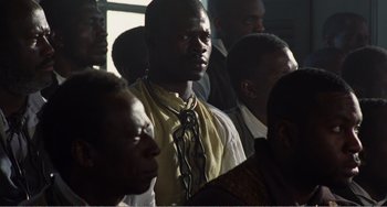 Movie still from “Amistad” (1997), directed by Steven Spielberg – A group of men standing next to each other in a room; Close Up shot, High angle