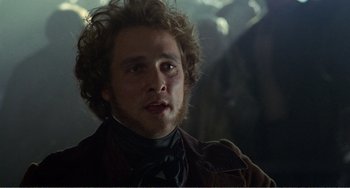 Movie still from “Amistad” (1997), directed by Steven Spielberg – A person with curly hair wearing a jacket; Close Up shot, Over the shoulder angle