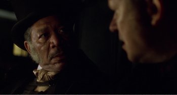 Movie still from “Amistad” (1997), directed by Steven Spielberg – A man in a suit and a hat looking at another man in a suit and a hat; Close Up shot, Over the shoulder angle