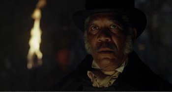 Movie still from “Amistad” (1997), directed by Steven Spielberg – An older man wearing a top hat and a black suit; Close Up shot, Low angle