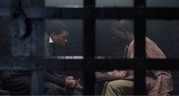Movie still from “Amistad” (1997), directed by Steven Spielberg – Two men sitting in a cell looking at each other; Medium shot, Over the shoulder angle