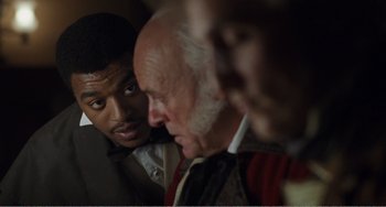 Movie still from “Amistad” (1997), directed by Steven Spielberg – A group of men standing next to each other in a room; Close Up shot, Over the shoulder angle