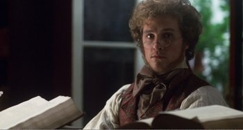 Movie still from “Amistad” (1997), directed by Steven Spielberg – A man sitting in front of an open book; Close Up shot, Over the shoulder angle
