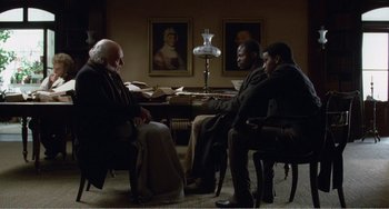 Movie still from “Amistad” (1997), directed by Steven Spielberg – A group of people sitting in a room; Wide shot, High angle