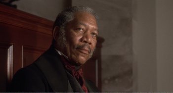 Movie still from “Amistad” (1997), directed by Steven Spielberg – An older man wearing a suit and a red neck tie; Close Up shot, Low angle