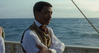 Movie still from “Amistad” (1997), directed by Steven Spielberg – A man standing on top of a boat near the ocean; Medium shot, Over the shoulder angle