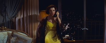 Movie still from “An Affair to Remember” (1957), directed by Leo McCarey – A woman in a yellow dress talking on a phone; Medium shot, High angle