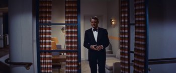Movie still from “An Affair to Remember” (1957), directed by Leo McCarey – A man in a tuxedo standing in a living room; Medium shot, Low angle