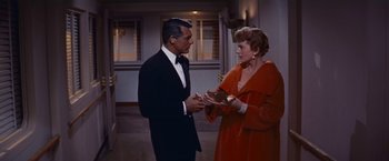 Movie still from “An Affair to Remember” (1957), directed by Leo McCarey – A man and a woman in formal wear exchanging cards; Medium shot, High angle