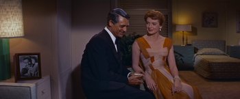 Movie still from “An Affair to Remember” (1957), directed by Leo McCarey – A man and a woman are looking at a cell phone; Medium shot, High angle