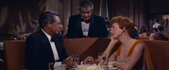 Movie still from “An Affair to Remember” (1957), directed by Leo McCarey – A group of people sitting at a table with drinks; Medium shot, Over the shoulder angle