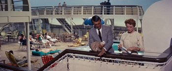 Movie still from “An Affair to Remember” (1957), directed by Leo McCarey – A man in a suit and tie standing next to a pool; Medium shot, High angle