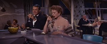 Movie still from “An Affair to Remember” (1957), directed by Leo McCarey – A woman drinking a glass of wine at a bar; Medium shot, Low angle