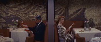 Movie still from “An Affair to Remember” (1957), directed by Leo McCarey – A man and a woman sitting next to each other on a train; Medium shot, Overhead angle