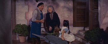 Movie still from “An Affair to Remember” (1957), directed by Leo McCarey – An older couple and a little girl standing next to a wagon; Medium shot, Low angle