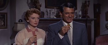 Movie still from “An Affair to Remember” (1957), directed by Leo McCarey – A man and a woman are standing in front of a fireplace; Close Up shot, Over the shoulder angle