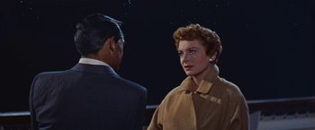 Movie still from “An Affair to Remember” (1957), directed by Leo McCarey – An older man and a younger woman standing next to each other in front of a night sky; Medium shot, Low angle