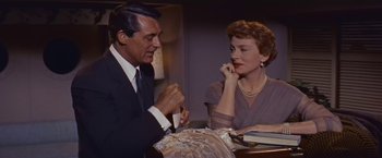 Movie still from “An Affair to Remember” (1957), directed by Leo McCarey – A man and a woman sitting at a dinner table; Medium shot, High angle