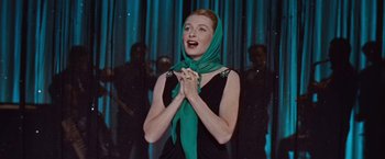 Movie still from “An Affair to Remember” (1957), directed by Leo McCarey – A woman in a black dress and a green head scarf clasping her hands; Medium shot, Low angle