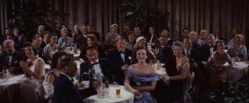 Movie still from “An Affair to Remember” (1957), directed by Leo McCarey – A group of people sitting at a table with drinks; Wide shot, High angle