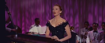 Movie still from “An Affair to Remember” (1957), directed by Leo McCarey – A woman in a black dress is standing in front of a bar; Medium shot, Low angle