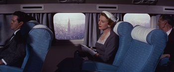 Movie still from “An Affair to Remember” (1957), directed by Leo McCarey – A woman sitting on a plane looking out a window; Medium shot, High angle