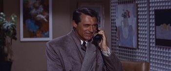 Movie still from “An Affair to Remember” (1957), directed by Leo McCarey – A man talking on a phone while wearing a suit and tie; Medium shot, Over the shoulder angle