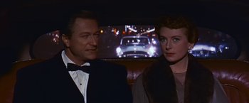 Movie still from “An Affair to Remember” (1957), directed by Leo McCarey – A man and a woman sitting in front of a car; Medium shot, Over the shoulder angle