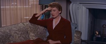 Movie still from “An Affair to Remember” (1957), directed by Leo McCarey – A woman sitting on a couch wearing a red dress; Close Up shot, High angle