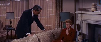 Movie still from “An Affair to Remember” (1957), directed by Leo McCarey – A man and a woman sitting on a couch in a living room; Medium shot, High angle