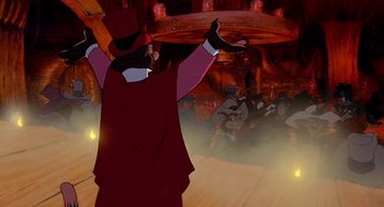 Movie still from “An American Tail: Fievel Goes West” (1991), directed by Simon Wells – A man wearing a top hat and a long red coat; Wide shot, Low angle