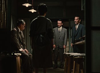 A group of men in suits standing around in a room