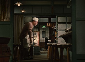 A man standing in front of a table in a kitchen