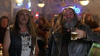 Movie still from “Anchorman: The Legend of Ron Burgundy” (2004), directed by Adam McKay – A group of men with long hair and beards are drinking beer; Medium shot, Low angle