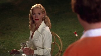 Movie still from “Anchorman: The Legend of Ron Burgundy” (2004), directed by Adam McKay – A woman sitting at a table holding a glass of wine; Medium shot, Over the shoulder angle
