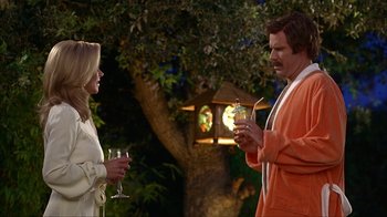 Movie still from “Anchorman: The Legend of Ron Burgundy” (2004), directed by Adam McKay – A man and a woman holding wine glasses in front of a tree; Medium shot, Over the shoulder angle