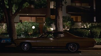 Movie still from “Anchorman: The Legend of Ron Burgundy” (2004), directed by Adam McKay – A car parked in front of a building at night; Wide shot, High angle
