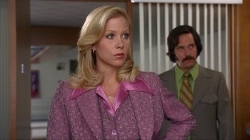 Movie still from “Anchorman: The Legend of Ron Burgundy” (2004), directed by Adam McKay – A woman in a purple dress and a man in a green suit; Medium shot, Over the shoulder angle