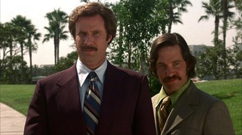 Movie still from “Anchorman: The Legend of Ron Burgundy” (2004), directed by Adam McKay – Two men standing next to each other wearing suits and ties; Close Up shot, Low angle